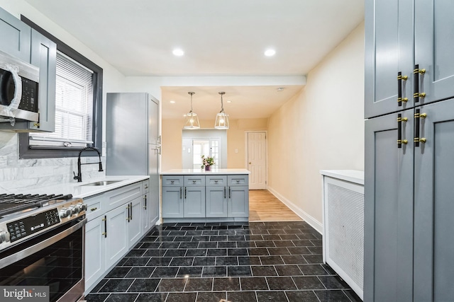 kitchen featuring a wealth of natural light, a peninsula, stainless steel appliances, and a sink