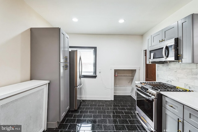 kitchen with recessed lighting, gray cabinetry, decorative backsplash, light countertops, and stainless steel appliances