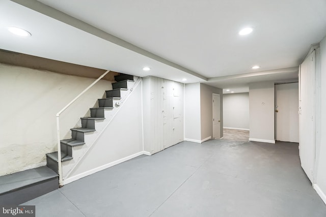 finished below grade area with recessed lighting, baseboards, and stairs