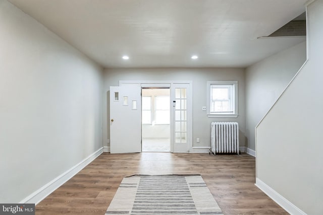 foyer featuring recessed lighting, radiator, wood finished floors, and baseboards