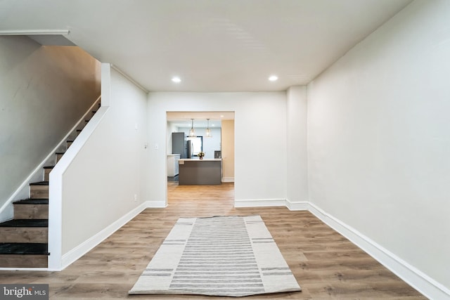 interior space with stairway, recessed lighting, baseboards, and wood finished floors