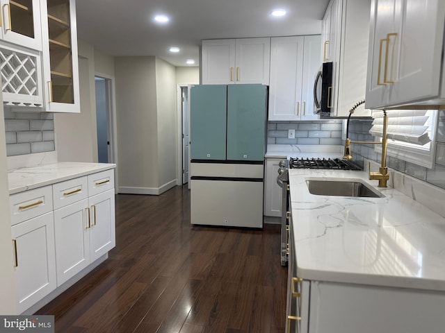 kitchen featuring stainless steel microwave, light stone countertops, dark wood-type flooring, and white cabinets