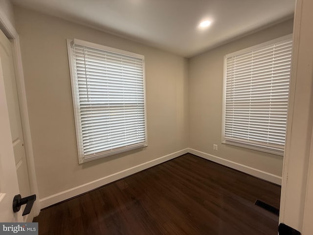 unfurnished bedroom featuring dark wood finished floors, baseboards, and visible vents