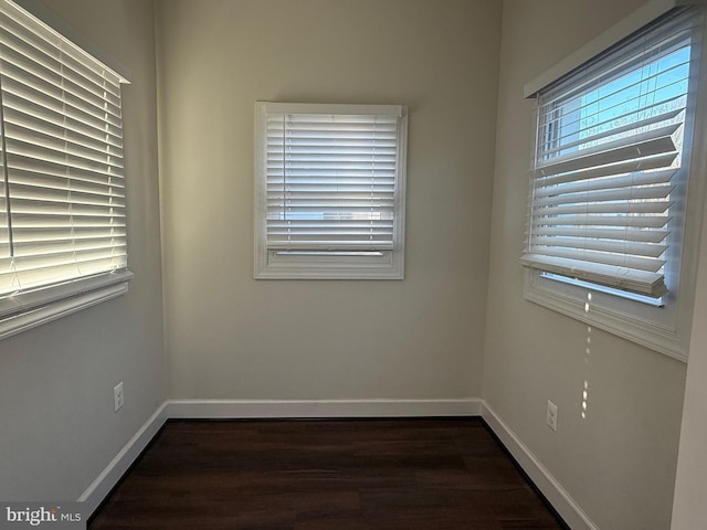 unfurnished room featuring dark wood finished floors and baseboards