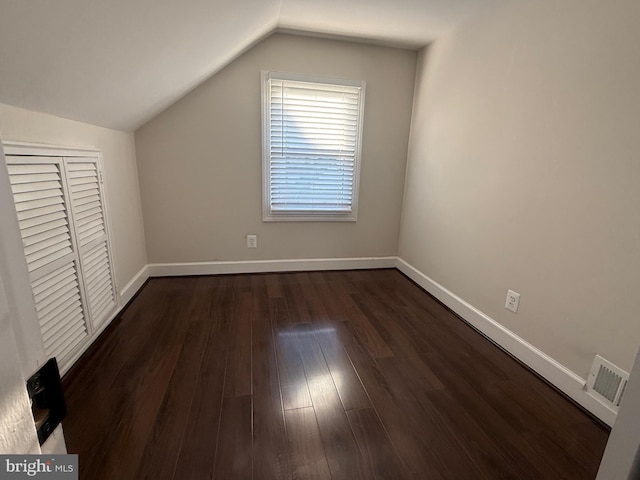 bonus room with lofted ceiling, dark wood-style floors, baseboards, and visible vents