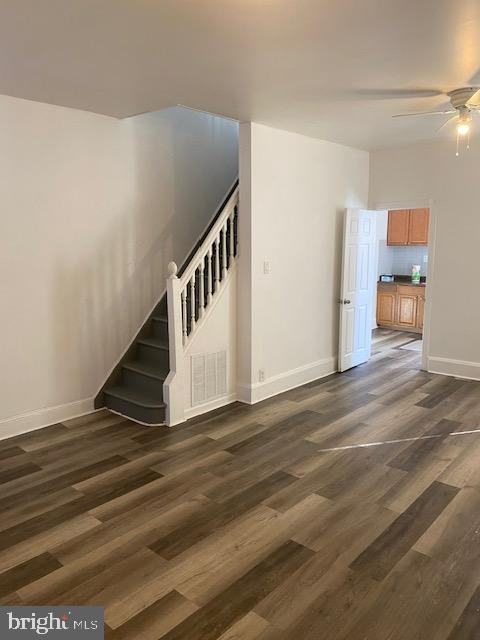 staircase featuring ceiling fan, baseboards, and wood finished floors