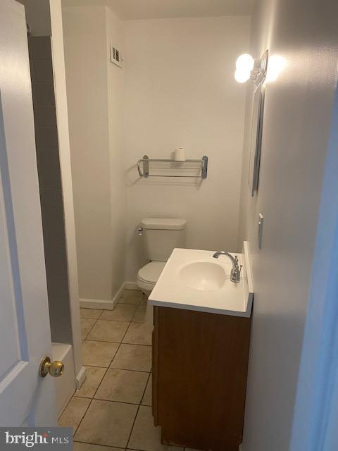 bathroom featuring vanity, visible vents, baseboards, tile patterned flooring, and toilet