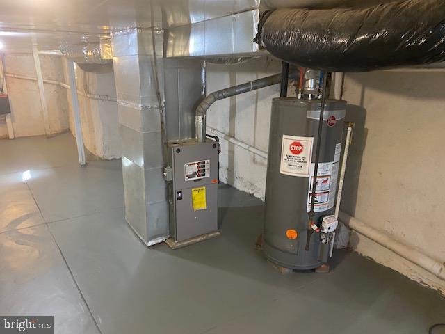 utility room featuring heating unit and gas water heater