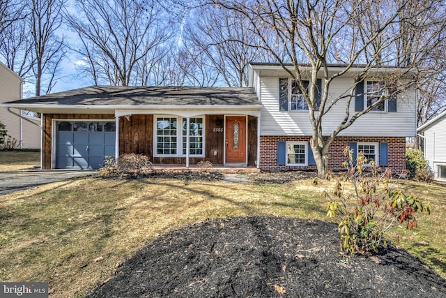 tri-level home featuring driveway, brick siding, an attached garage, and a front lawn