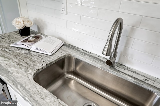 details with light stone counters, backsplash, and a sink