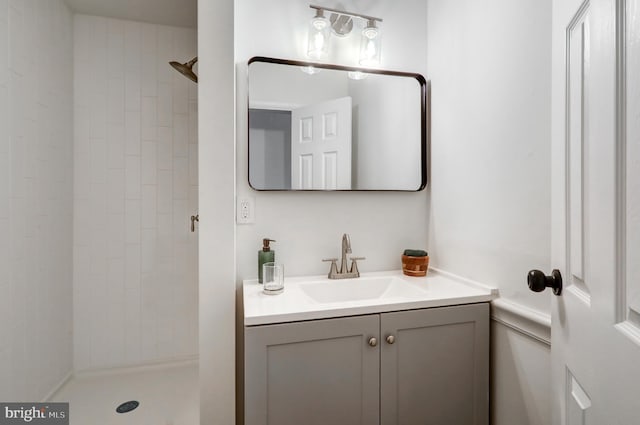 bathroom featuring tiled shower and vanity