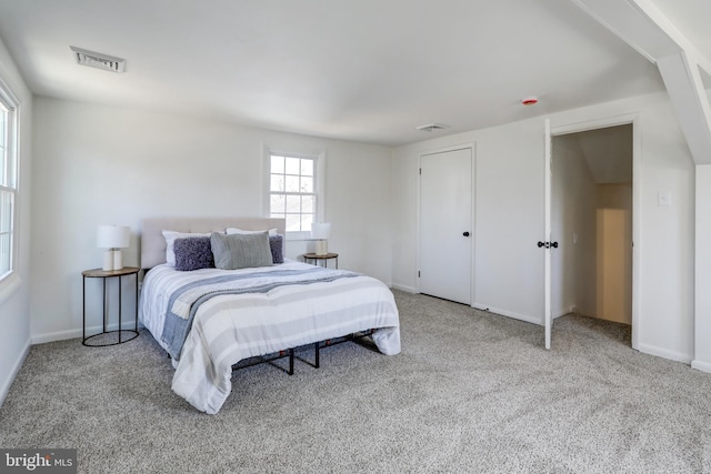 carpeted bedroom with visible vents and baseboards