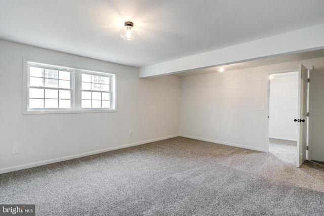 unfurnished room featuring carpet and baseboards