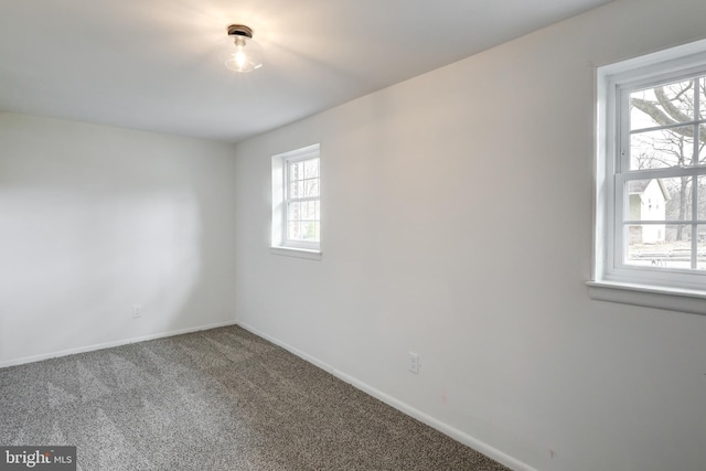 empty room featuring baseboards and carpet flooring