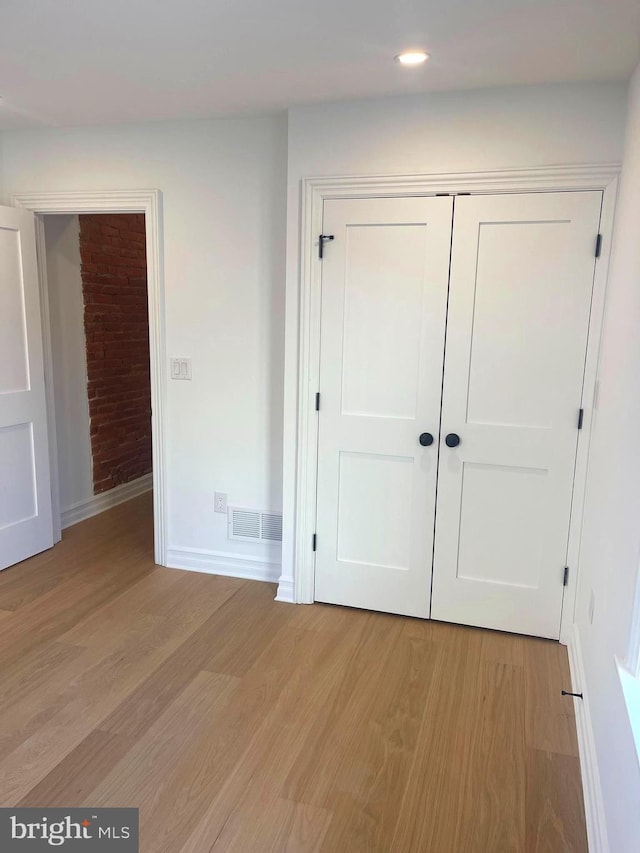 unfurnished bedroom with baseboards, visible vents, light wood-style flooring, recessed lighting, and a closet