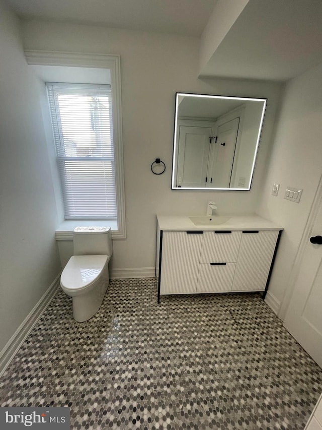 bathroom featuring vanity, toilet, and baseboards