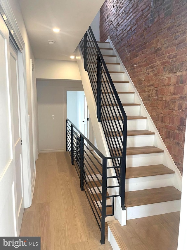 staircase featuring baseboards and wood finished floors