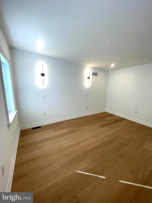 spare room featuring recessed lighting, visible vents, baseboards, and wood finished floors