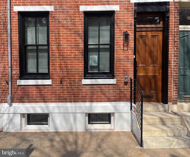 property entrance featuring brick siding