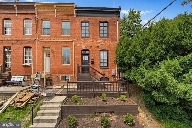 444 Grindall St, Baltimore, MD 21230 - view of front of home with entry steps, brick siding, a garden, and a deck