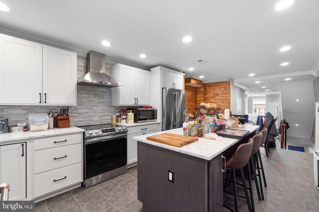 444 Grindall St, Baltimore, MD 21230 - kitchen with appliances with stainless steel finishes, wall chimney exhaust hood, a kitchen breakfast bar, a center island, and decorative backsplash