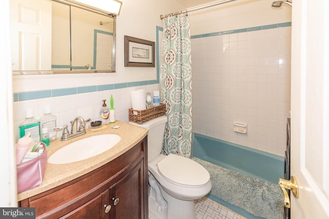 bathroom with vanity, tile walls, toilet, and shower / bath combo