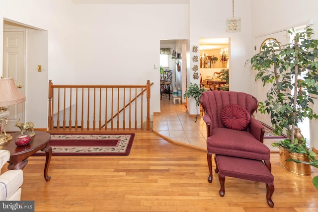 living area featuring an upstairs landing, an inviting chandelier, and wood finished floors