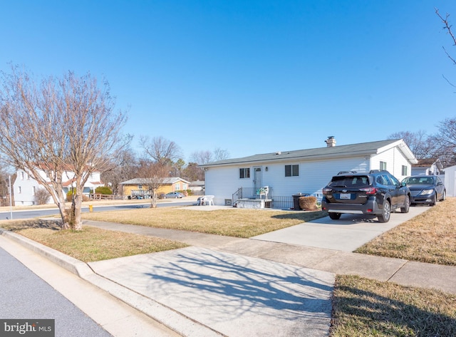 view of front facade with concrete driveway and a front yard