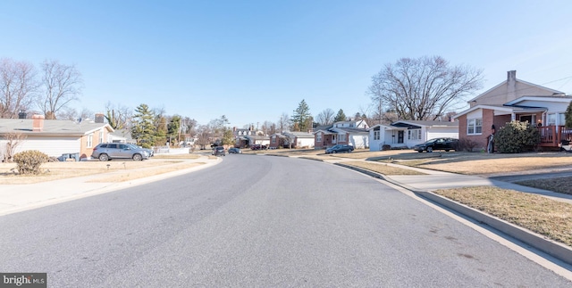 view of street with sidewalks, a residential view, and curbs