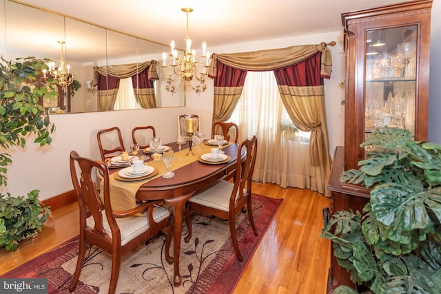 dining area featuring wood-type flooring and a chandelier