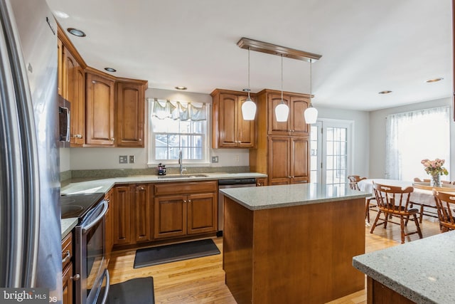 kitchen with a sink, a healthy amount of sunlight, brown cabinets, and stainless steel appliances