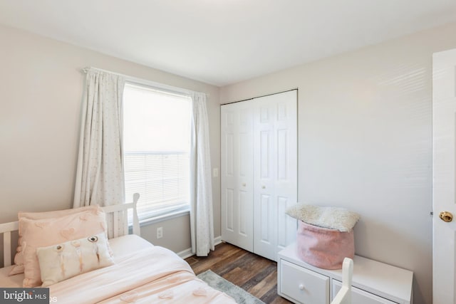 bedroom with a closet, baseboards, and dark wood-style flooring