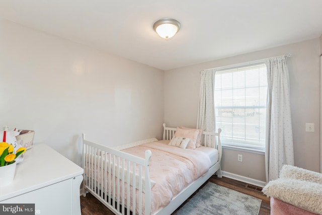 bedroom with visible vents, dark wood-style floors, and baseboards