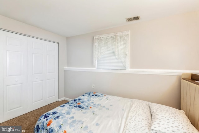 carpeted bedroom featuring a closet and visible vents