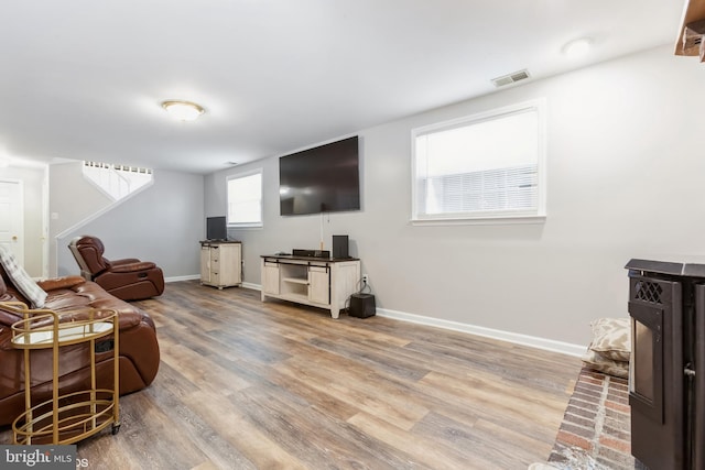 living area with visible vents, baseboards, and wood finished floors