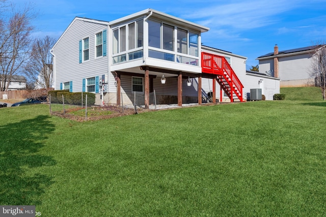 rear view of property with central air condition unit, a yard, stairs, and a sunroom