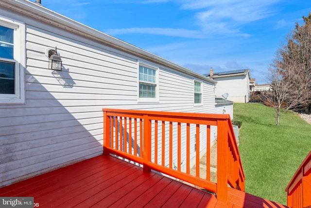 wooden deck featuring a lawn