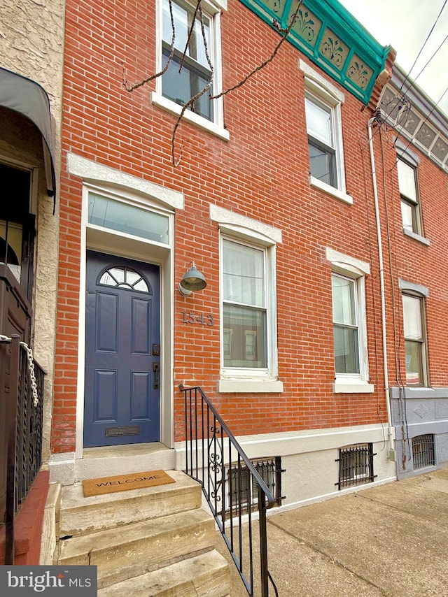 entrance to property featuring brick siding