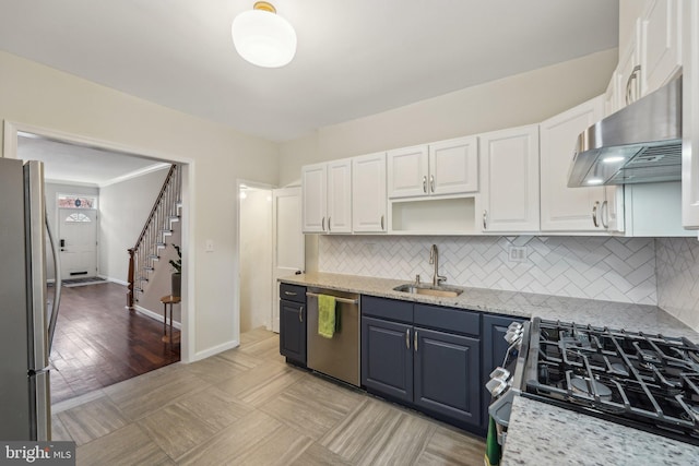 kitchen featuring a sink, stainless steel appliances, white cabinets, under cabinet range hood, and backsplash