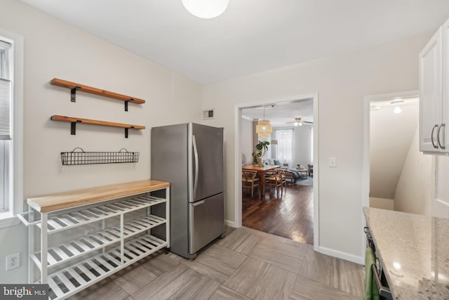 kitchen featuring light stone countertops, visible vents, open shelves, freestanding refrigerator, and ceiling fan