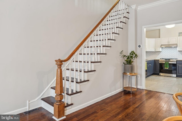 stairway with hardwood / wood-style flooring, baseboards, and ornamental molding