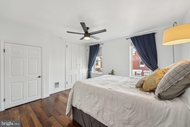 bedroom featuring visible vents, baseboards, ceiling fan, a closet, and dark wood-style flooring