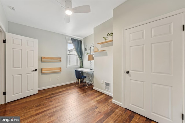 interior space featuring baseboards, wood-type flooring, visible vents, and a ceiling fan