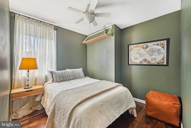 bedroom featuring wood finished floors, baseboards, and ceiling fan