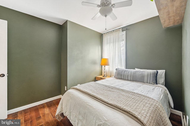 bedroom featuring a ceiling fan, baseboards, and wood finished floors