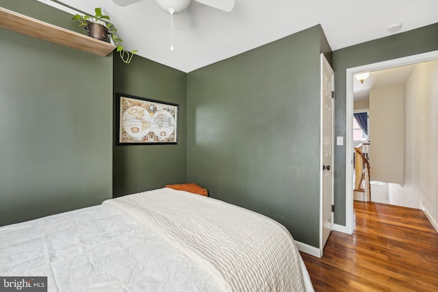 bedroom featuring ceiling fan, baseboards, and wood finished floors