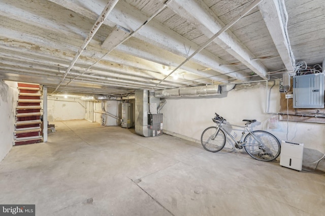 unfinished basement featuring electric panel, stairway, heating unit, and water heater