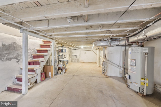 unfinished basement with stairway and water heater