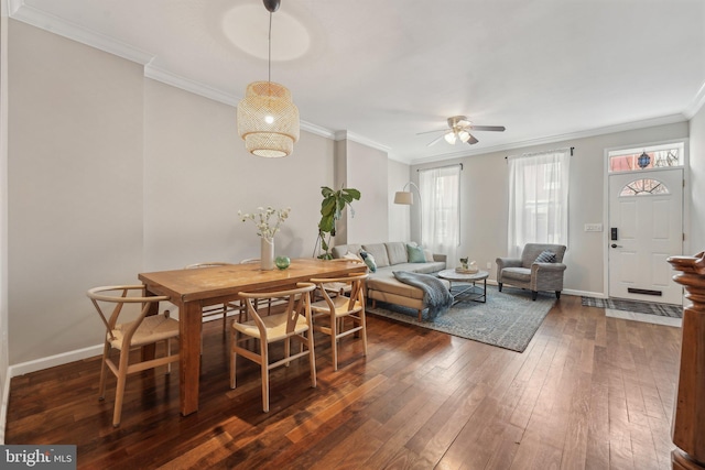 dining area with dark wood finished floors, baseboards, crown molding, and a ceiling fan