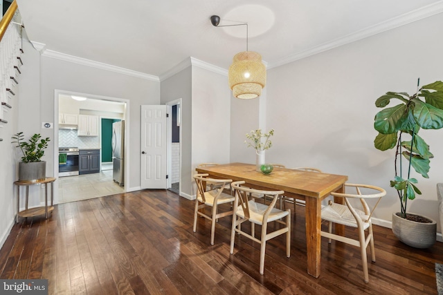 dining area with crown molding, baseboards, and dark wood-style flooring